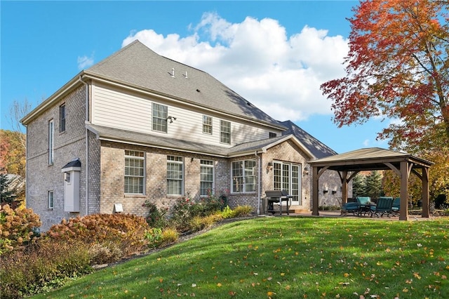 rear view of property featuring a yard, a gazebo, and a patio area