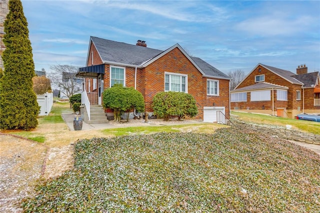 bungalow-style house with a garage and a front lawn