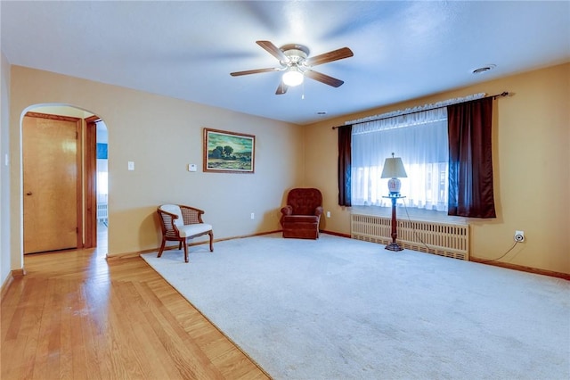 unfurnished room featuring radiator and ceiling fan