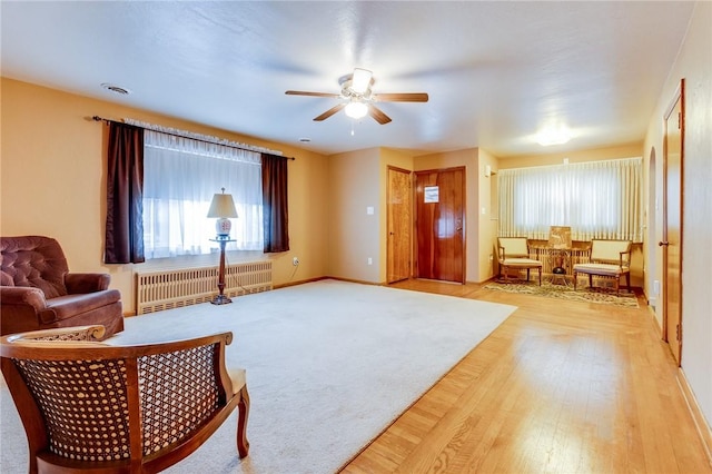 sitting room featuring radiator, hardwood / wood-style flooring, and ceiling fan