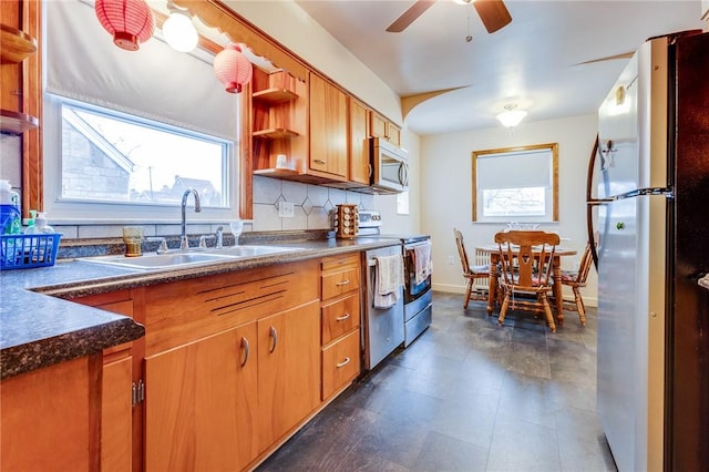 kitchen featuring appliances with stainless steel finishes, sink, backsplash, and ceiling fan