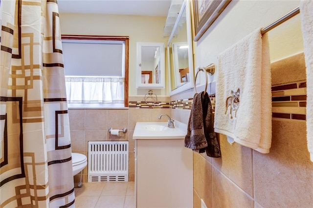 bathroom featuring toilet, tile walls, vanity, radiator, and tile patterned flooring