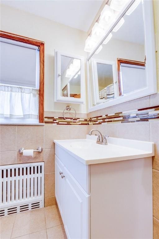 bathroom featuring vanity, radiator heating unit, tile patterned floors, and tile walls