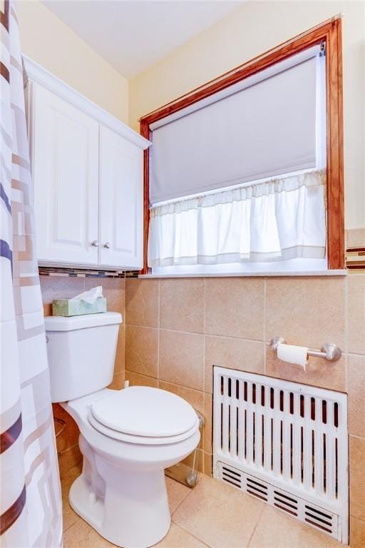 bathroom with radiator, tile walls, tile patterned floors, and toilet