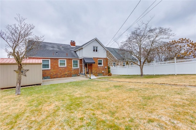 rear view of property featuring a yard and a patio area