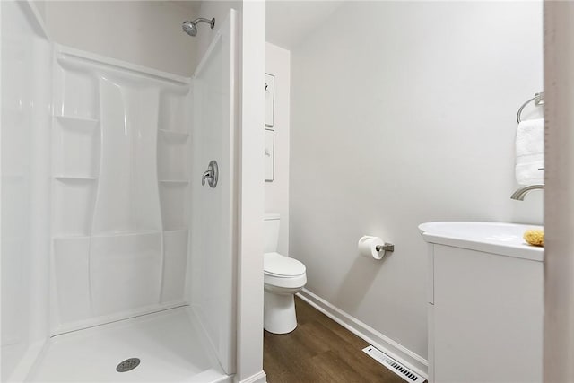 bathroom featuring hardwood / wood-style floors, toilet, and a shower