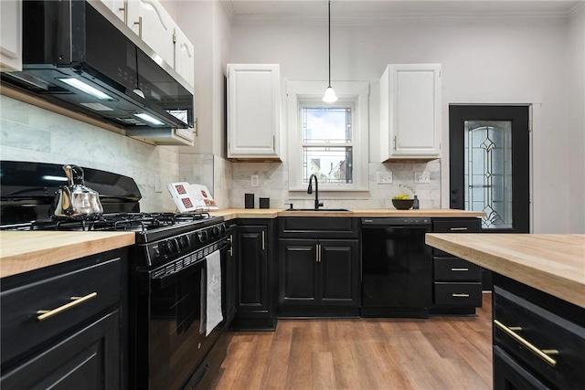 kitchen featuring sink, wooden counters, decorative light fixtures, white cabinets, and black appliances