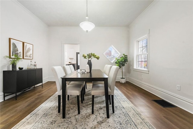 dining room with ornamental molding and dark hardwood / wood-style flooring