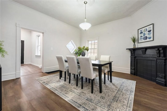 dining space with dark hardwood / wood-style flooring and crown molding