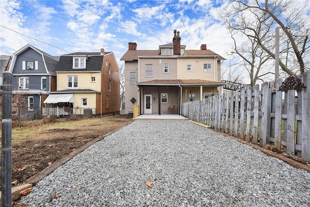 rear view of house with central AC and covered porch