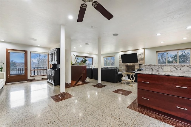 interior space featuring a large fireplace and ceiling fan