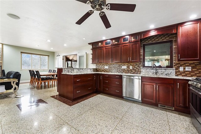 kitchen with tasteful backsplash, appliances with stainless steel finishes, kitchen peninsula, and sink