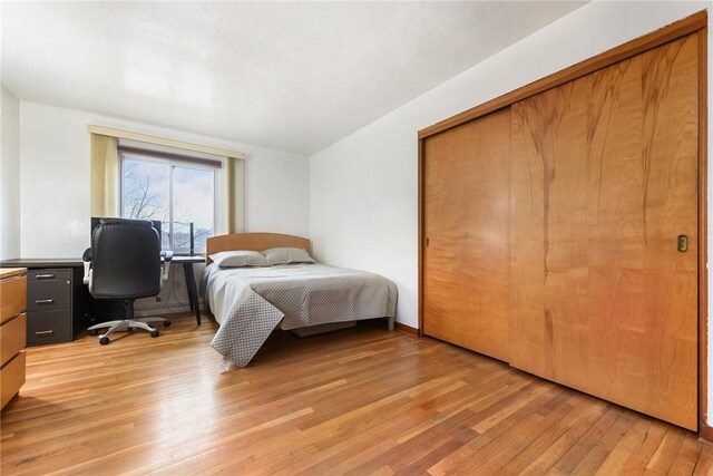 bedroom with light hardwood / wood-style flooring and a closet