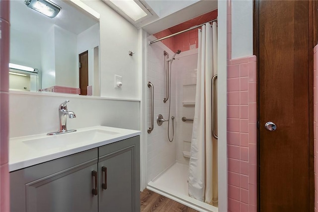 bathroom with hardwood / wood-style flooring, vanity, and curtained shower