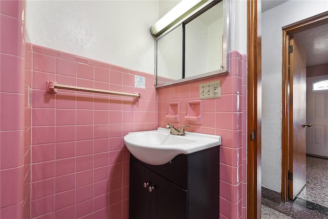 bathroom featuring vanity and tile walls