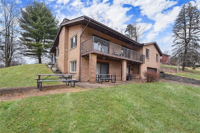 rear view of house with a garage, a lawn, and a patio area