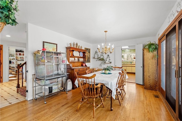 dining space with an inviting chandelier and light hardwood / wood-style floors