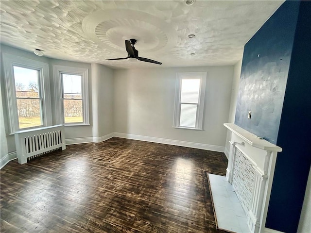 unfurnished living room featuring radiator, a textured ceiling, dark wood-type flooring, and ceiling fan