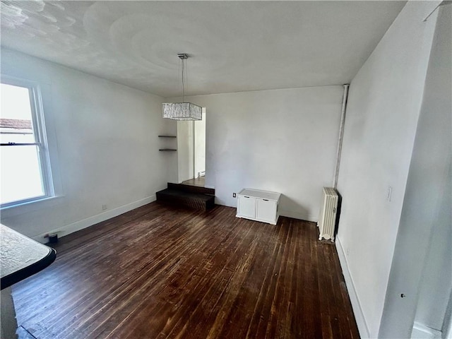 unfurnished dining area with radiator and dark hardwood / wood-style flooring