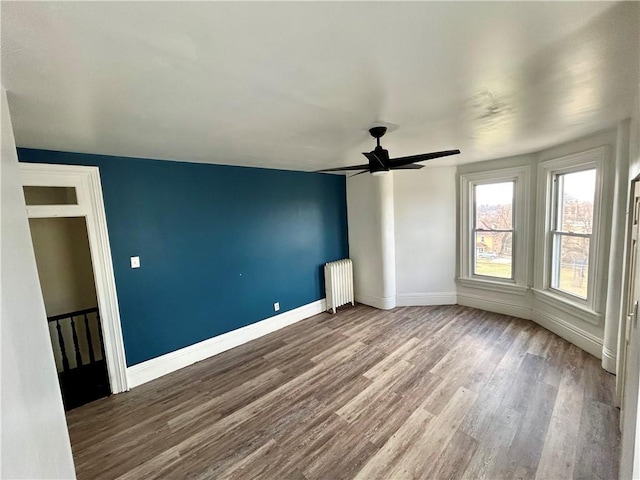 interior space featuring hardwood / wood-style floors, radiator heating unit, and ceiling fan