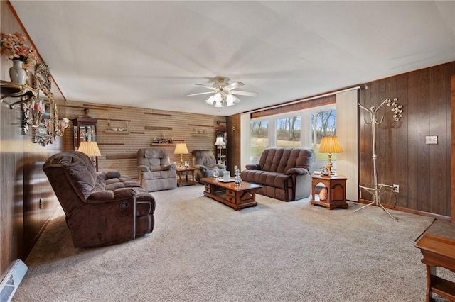 carpeted living room with wooden walls and ceiling fan