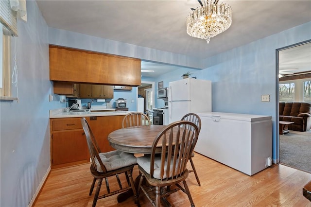 dining room featuring light hardwood / wood-style flooring and a notable chandelier