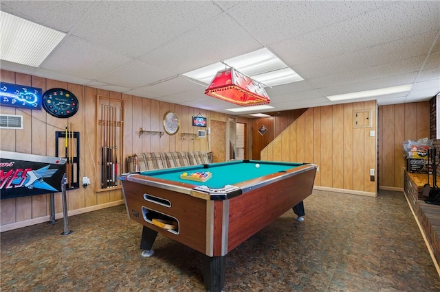 game room featuring a drop ceiling and wood walls