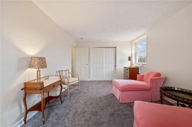 sitting room featuring dark carpet