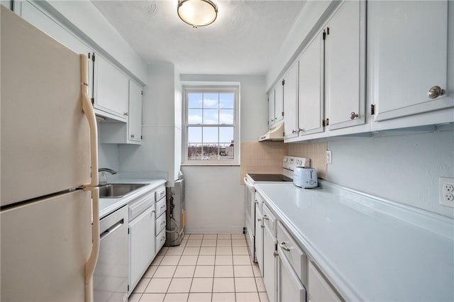 kitchen with white cabinetry, sink, light tile patterned floors, and white appliances