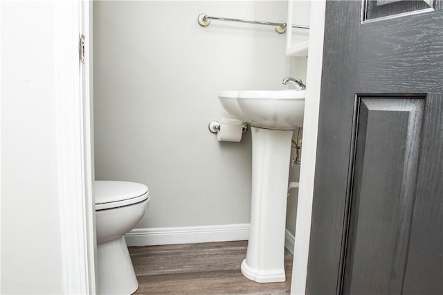 bathroom with hardwood / wood-style flooring and toilet