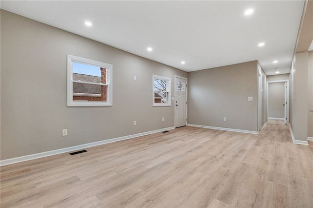 unfurnished room featuring a wealth of natural light and light hardwood / wood-style flooring