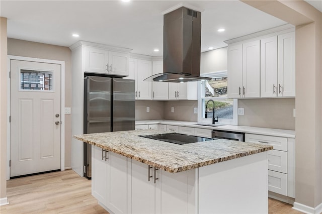 kitchen featuring white cabinetry, light stone counters, island range hood, and a kitchen island