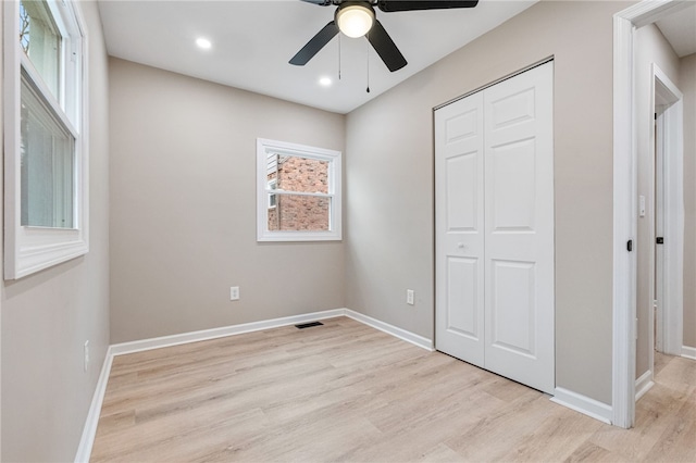 unfurnished bedroom featuring ceiling fan, light hardwood / wood-style floors, and a closet