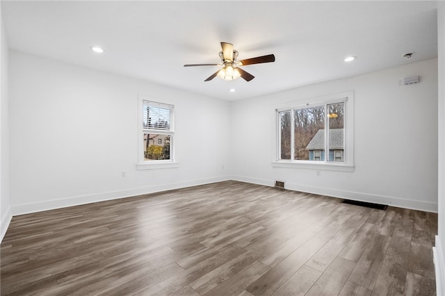 unfurnished room with a ceiling fan, recessed lighting, dark wood finished floors, and baseboards