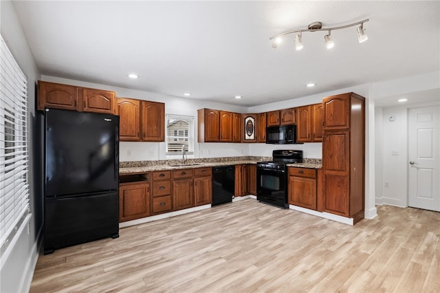 kitchen with recessed lighting, brown cabinetry, a sink, light wood-type flooring, and black appliances