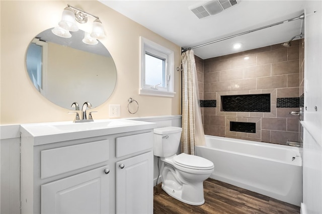 bathroom featuring toilet, wood finished floors, vanity, visible vents, and shower / bath combo