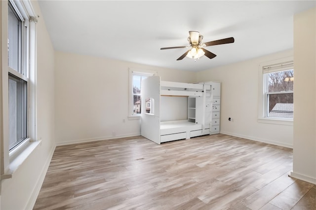 unfurnished bedroom with a ceiling fan, light wood-type flooring, and baseboards