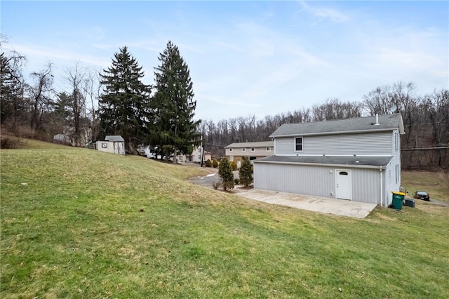 view of yard with a patio area, an outdoor structure, and a storage unit