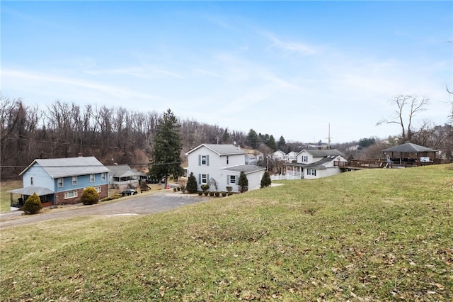 view of yard featuring driveway and a residential view