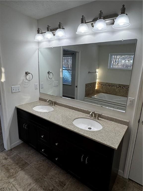 bathroom with vanity, a textured ceiling, and a tub to relax in