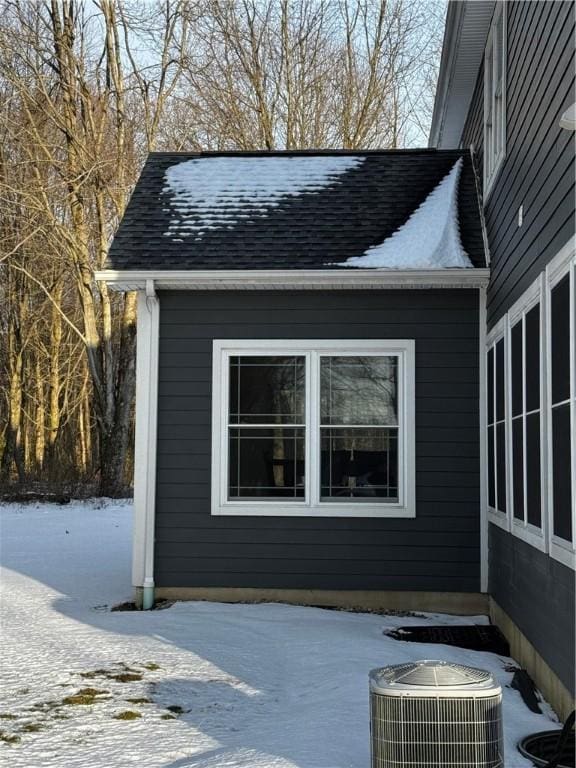 snow covered property featuring central air condition unit