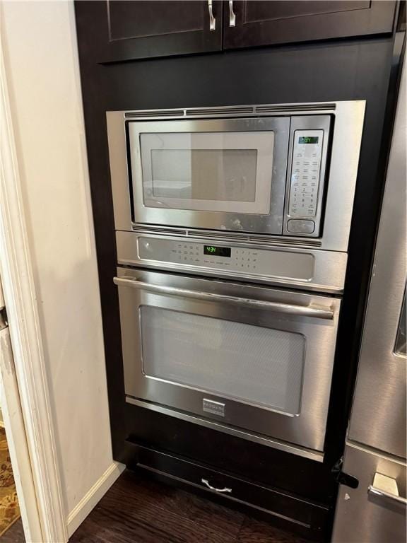 interior details featuring stainless steel appliances and dark wood-type flooring