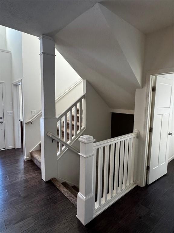 staircase featuring hardwood / wood-style flooring and vaulted ceiling