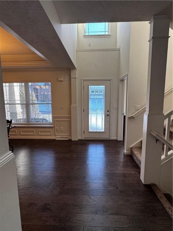 entryway featuring a wealth of natural light, dark wood-type flooring, and ornamental molding