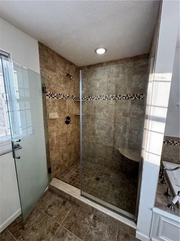 bathroom featuring a shower with door and a textured ceiling