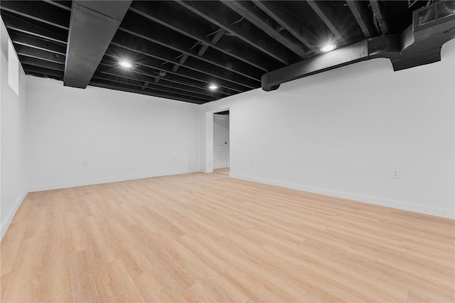 basement with light hardwood / wood-style flooring