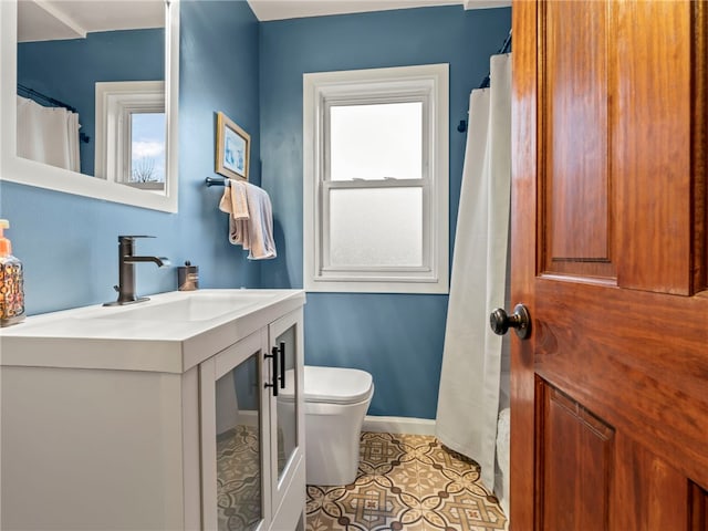 bathroom with tile patterned floors, plenty of natural light, toilet, and vanity