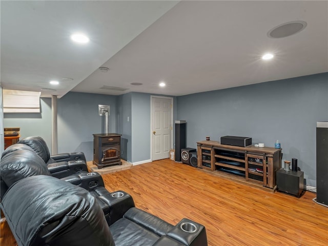 living room featuring a wood stove and light hardwood / wood-style floors