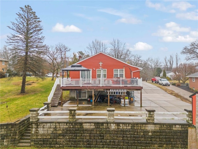 rear view of house featuring a wooden deck, a gazebo, and a yard