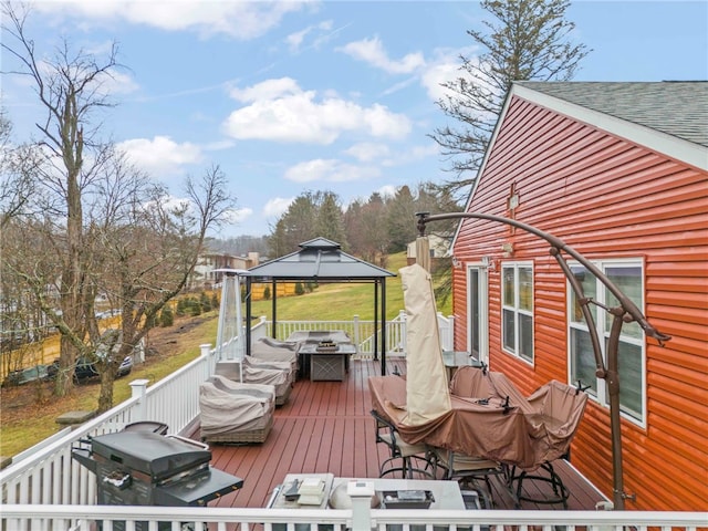 wooden terrace with a gazebo and a grill